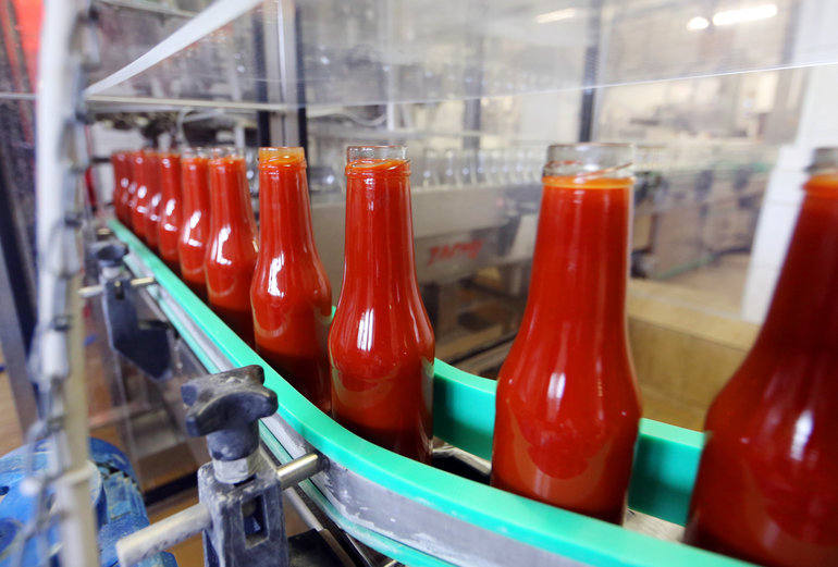 Tomatenketchup in der 450ml Glasflasche bei der Produktion.